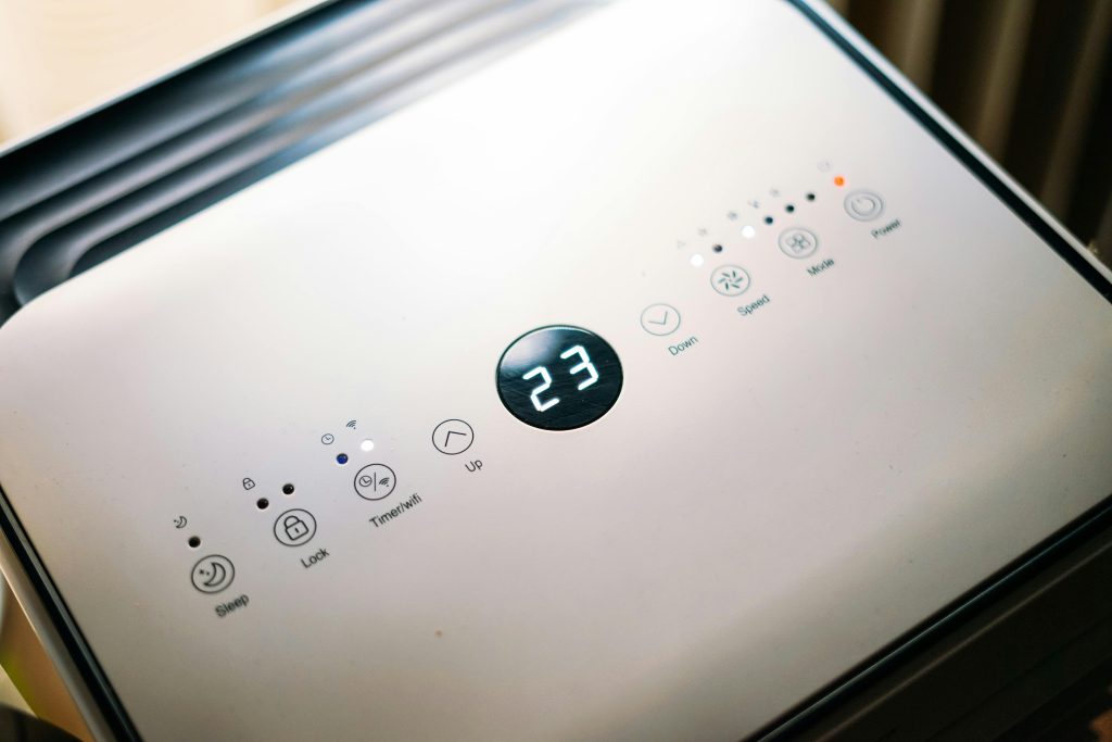 Close-up of a sleek air conditioner control panel displaying temperature.